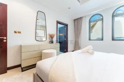 a white bedroom with a bed and two mirrors at Beachfront 6BR and Assistant's Room Villa with Private Pool, Palm Villa, Palm Jumeirah by Deluxe Holiday Homes in Dubai