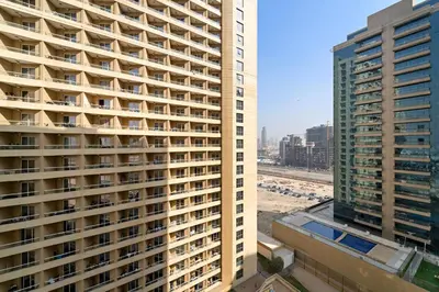 an aerial view of a tall building in a city at Modern Studio in Production City in Dubai