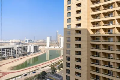 a view of a building and a river at Modern Studio in Production City in Dubai