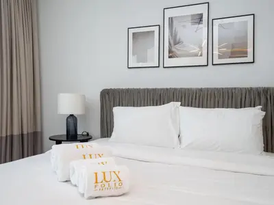 a bedroom with a white bed with three pictures on the wall at Waterfront Dubai Marina 3-Bedroom Sanctuary in Dubai