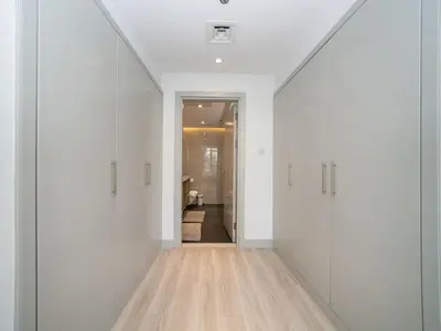 an empty hallway with white walls and wooden floors at Waterfront Dubai Marina 3-Bedroom Sanctuary in Dubai