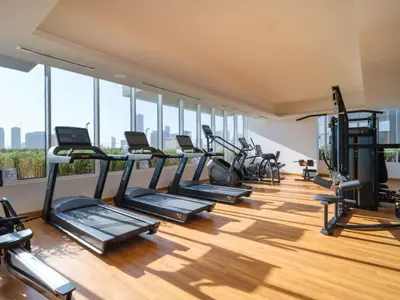 a gym with a row of treadmills and ellipticals at Elegant Studio in Bloom JVC with High-End Finishes in Dubai