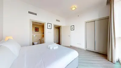 a white bedroom with a large bed and a bathroom at Al Bateen - Two Bedroom in JBR with City Views in Dubai