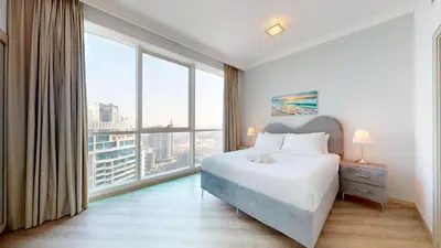 a bedroom with a large bed and large windows at Al Bateen - Two Bedroom in JBR with City Views in Dubai