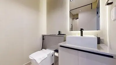 a white bathroom with a sink and a toilet at Mag 980 - Cosy Studio with City Views in Meydan in Dubai