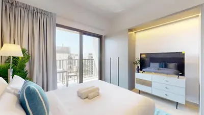 a bedroom with a white bed and a large window at Mag 980 - Cosy Studio with City Views in Meydan in Dubai