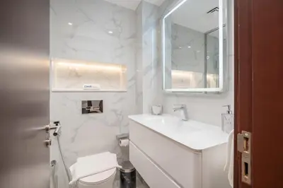 a white bathroom with a sink and a toilet at Stylish1BHK in Elite Residences, Marina with View in Dubai