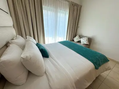 a bedroom with a large white bed with a window at Holiday Homes by DO- The Zumrud in Dubai