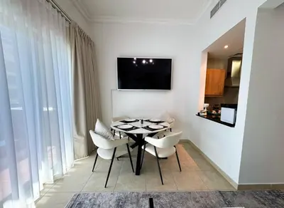 a dining room with a black table and white chairs at Holiday Homes by DO- The Zumrud in Dubai