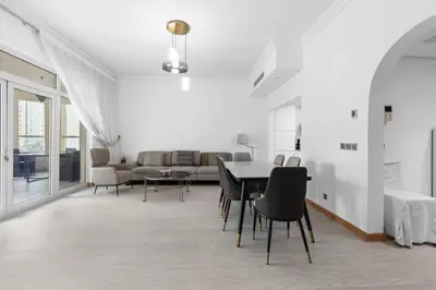 a white living room with a table and chairs at Bright 2 Bedroom Apartment, Beach & Pool Access in Dubai