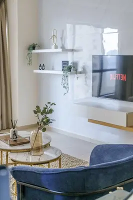a living room with a blue chair and a table at GuestReady - Contemporary Apt in JBR in Dubai