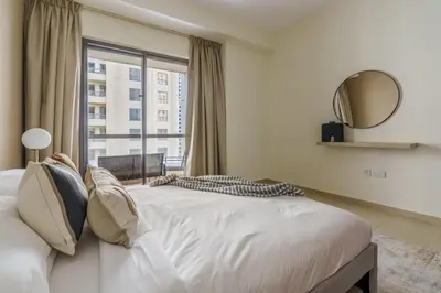 a bedroom with a bed with a large window at GuestReady - Contemporary Apt in JBR in Dubai