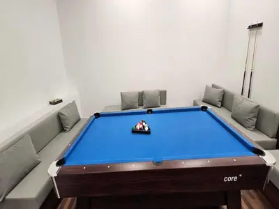 a pool table in a living room with afits at Luxury Studio in JVC in Dubai