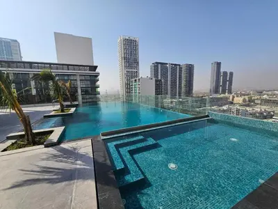 a large swimming pool on top of a building at Luxury Studio in JVC in Dubai