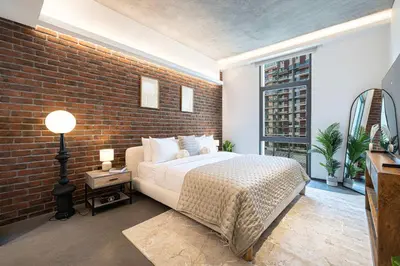 a bedroom with a brick wall and a bed at 1-Bedroom Apartment with Greenery & City Views in The Terraces in Dubai