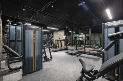 a gym with several treadmills and machines in it at Spacious 1BR with Modern Amenities in Westwood Grande JVC in Dubai