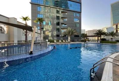 a swimming pool in the middle of a building at Spacious 1BR - Balcony & Pool View - Capital Bay in Dubai