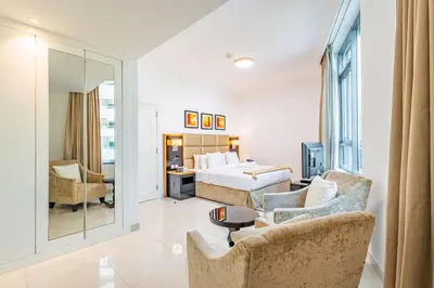 a hotel room with a bed and a living room at Spacious 1BR - Balcony & Pool View - Capital Bay in Dubai