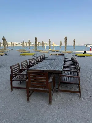 a long wooden table and chairs on the beach at TYS EXCELLENCE luxury apartment Palm Jumeirah DUBAI in Dubai
