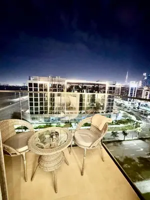 a balcony with wicker chairs and tables and a city at Burj Khalifa View studio in Dubai