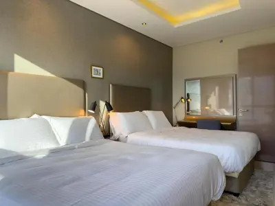 two beds in a hotel room with white sheets at HollywoodDXB Burj Khalifa View - 6Min To Dubai Mall in Dubai