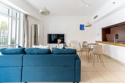 a blue couch in a living room with a table at HAVN - Studio in Downtown, 10mins to Dubai Mall in Dubai