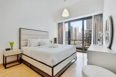 a white bedroom with a large bed and a large window at Dubai Marina View - 2BR APT with Pool & Gym in Dubai
