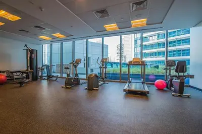 a gym with exercise equipment in a large room with windows at Dubai Marina View - 2BR APT with Pool & Gym in Dubai