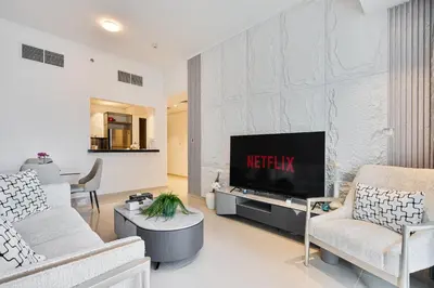 a living room with a tv on a wall at Dubai Marina View - 2BR APT with Pool & Gym in Dubai