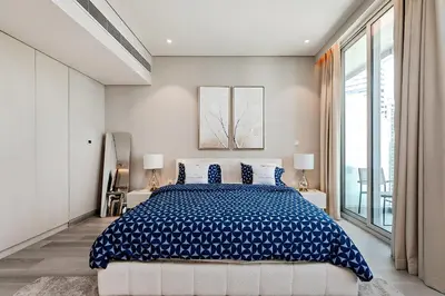 a bedroom with a large bed with blue and white sheets at Great Apartments at Marina Star with City View in Dubai