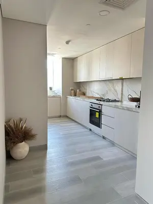 a kitchen with white cabinets and a floor with a plant at Entire apartment in Dubai Marina in Dubai