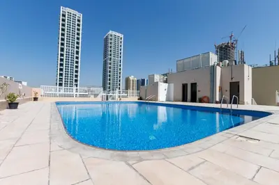 a swimming pool on top of a building with tall buildings at Cozy 1BR Apartment in Lolena Tower, JVC - Allsopp & Allsopp in Dubai