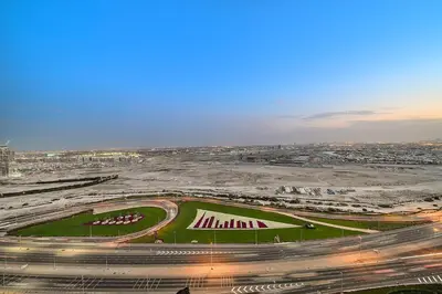 an aerial view of a race track in a city at FIRST CLASS 1BR Elegant Modern Retreat in Dubai