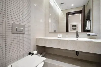 a bathroom with a sink and a toilet and a mirror at FIRST CLASS 1BR Elegant Modern Retreat in Dubai