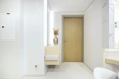 a hallway with a door and a vase on a table at UrbanHomes - Luxury and Cozy 3BDR Apartment in Business Bay Canal View in Dubai
