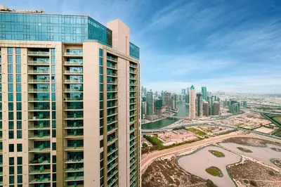a tall building with a view of a city at UrbanHomes - Luxury and Cozy 3BDR Apartment in Business Bay Canal View in Dubai