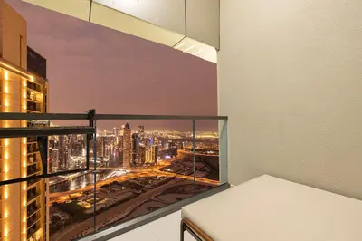 a room with a view of a city at night at UrbanHomes - Luxury and Cozy 3BDR Apartment in Business Bay Canal View in Dubai