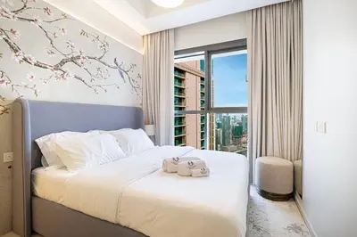 a bedroom with a bed with a large window at UrbanHomes - Luxury and Cozy 3BDR Apartment in Business Bay Canal View in Dubai