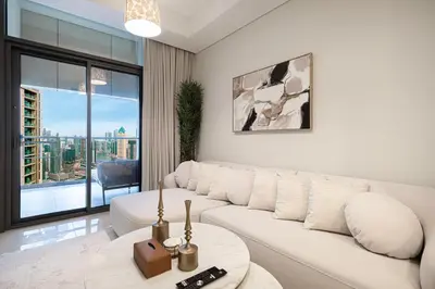 a living room with a white couch and a table at UrbanHomes - Luxury and Cozy 3BDR Apartment in Business Bay Canal View in Dubai
