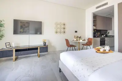 a white room with a bed and a kitchen at Frank Porter - Peninsula Five in Dubai