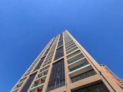 a tall building with a blue sky in the background at Frank Porter - Peninsula Five in Dubai