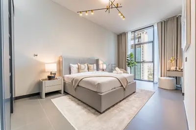 a bedroom with a bed and a large window at High-Rise 1BR with Lake and City Views and Minutes to Metro, MBL Royal, Jumeirah Lake Towers by Deluxe Holiday Homes in Dubai