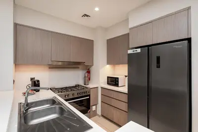 a kitchen with a stainless steel refrigerator and a sink at Luxury Apartment with Burj Khalifa Views - 5-Min Walk to Dubai Mall - Newly Upgraded - 10 people - Near Dubai Opera in Dubai