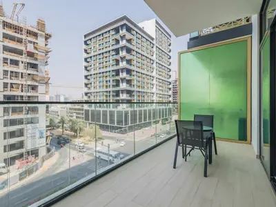 a balcony with a table and a view of a city at TRPS - Binghatti Emerald, Jumeirah Village Circle - Luxury 1BR Haven in Dubai