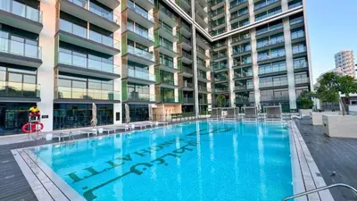 a large swimming pool in front of a building at TRPS - Binghatti Emerald, Jumeirah Village Circle - Luxury 1BR Haven in Dubai