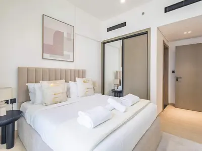 a bedroom with a large white bed with white pillows at TRPS - Binghatti Emerald, Jumeirah Village Circle - Luxury 1BR Haven in Dubai