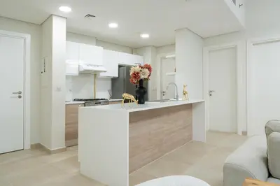 a kitchen with white cabinets and a counter with flowers on it at Veluxa - Renovated 1BHK next to Golf in Dubai