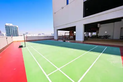 a tennis court on the roof of a building at Stylish 1BR Apartment - Central Location in JVC - Balcony - Holiday Boulevard in Dubai