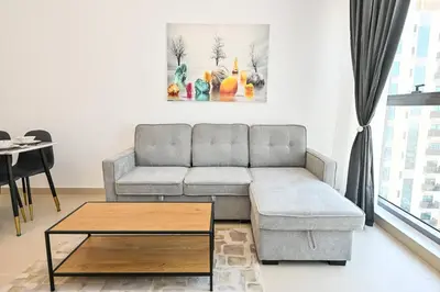a living room with a couch and a coffee table at Stylish 1BR Apartment - Central Location in JVC - Balcony - Holiday Boulevard in Dubai