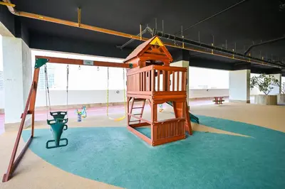 a playground with a slide and a swing at Stylish 1BR Apartment - Central Location in JVC - Balcony - Holiday Boulevard in Dubai